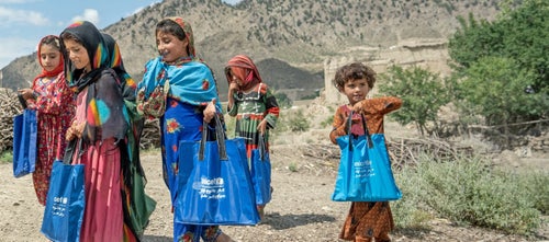 A group of girl are holding UNICEF tote bags
