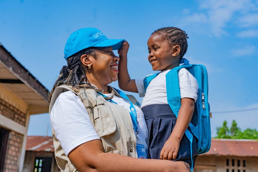 A UNICEF staff member holding a child.