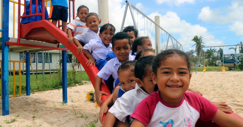 A group of children queue up on a slide