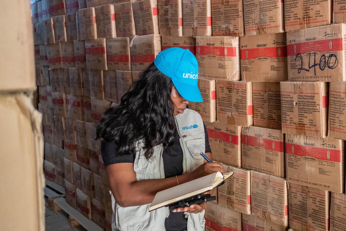 A UNICEF Nutrition Specialist in Nigeria inspects boxes of RUTF at a storage warehouse.
