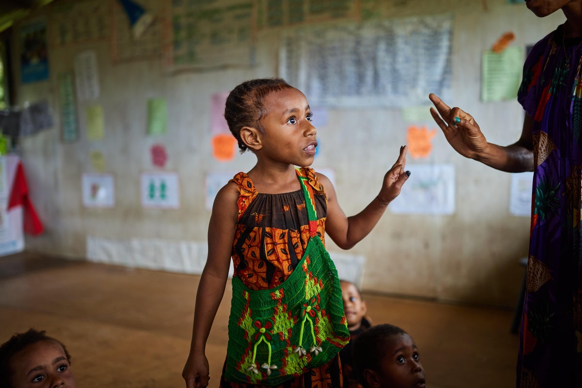 Unable to hear or speak, Phillandrah communicates with one of her teachers, Tane, who is trained in inclusive education in Papua New Guinea.   