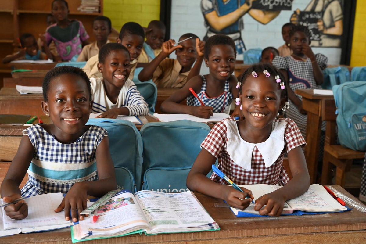 Girls in a classroom in Cote d'Ivorie smiling at the camera