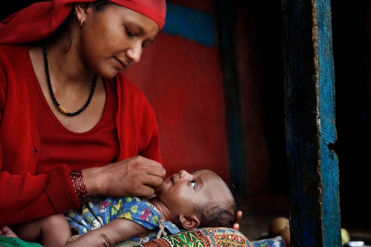 Sharmila Pariyar sits with her daughter in Nepal in 2015. 
 