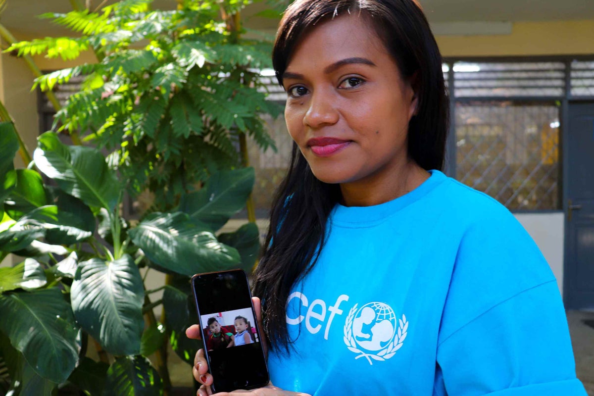 UNICEF Timor-Leste Health Officer Jonia Lourença Nunes Brites da Cruz shows a photo of her two children, son Gianpiero (8) and daughter Gloria (2), at the UNICEF Timor-Leste office in Dili.