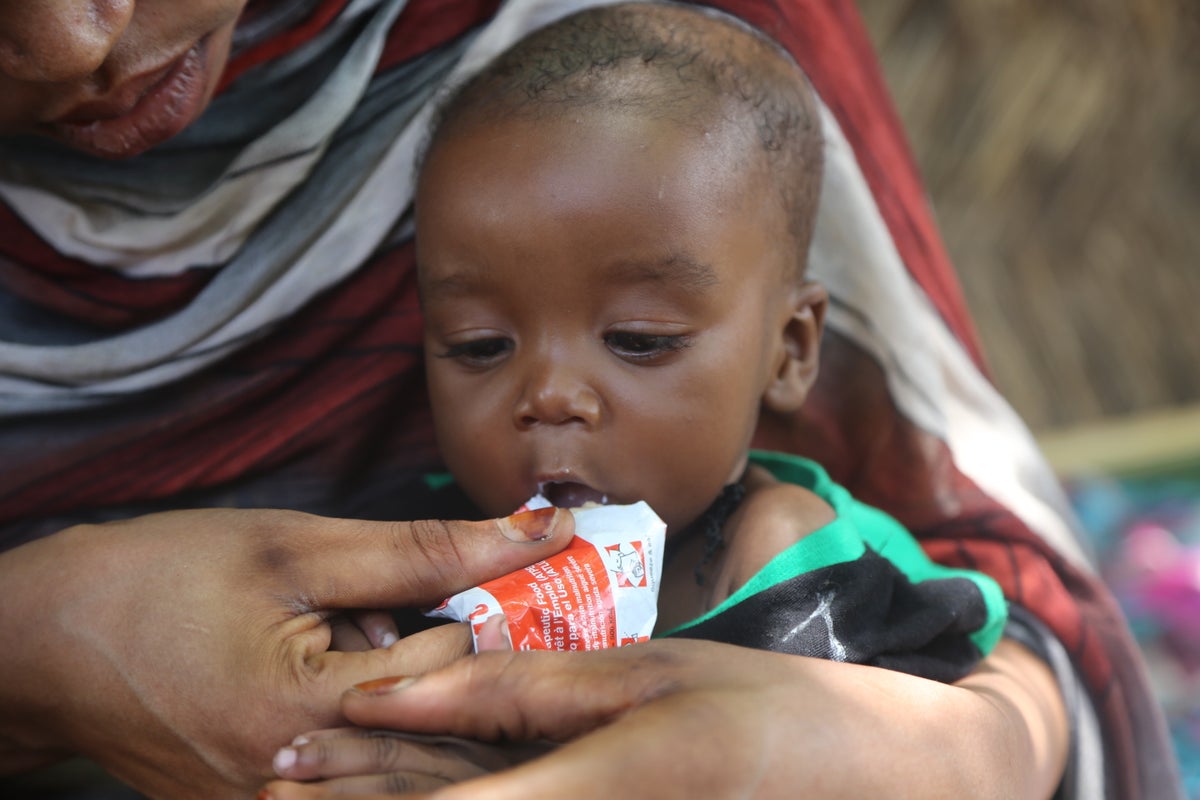 Mother feeds her six-month-old son with ready-to-use-therapeutic food, to help him recover from severe acute malnutrition.