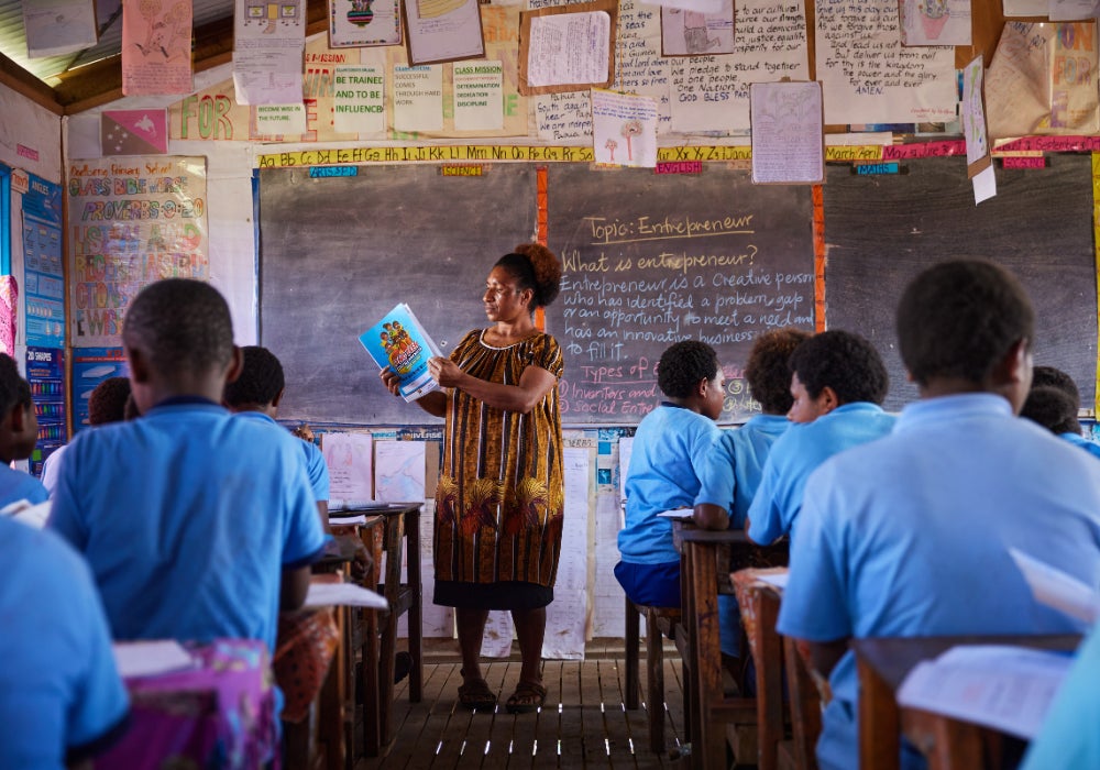 A women standing in front of a chalkboard in a classroom