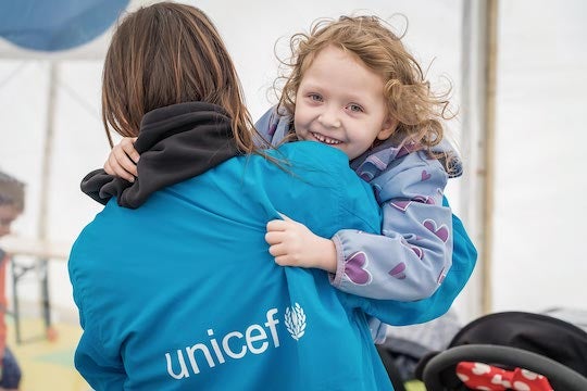 UNICEF staff member and smiling child