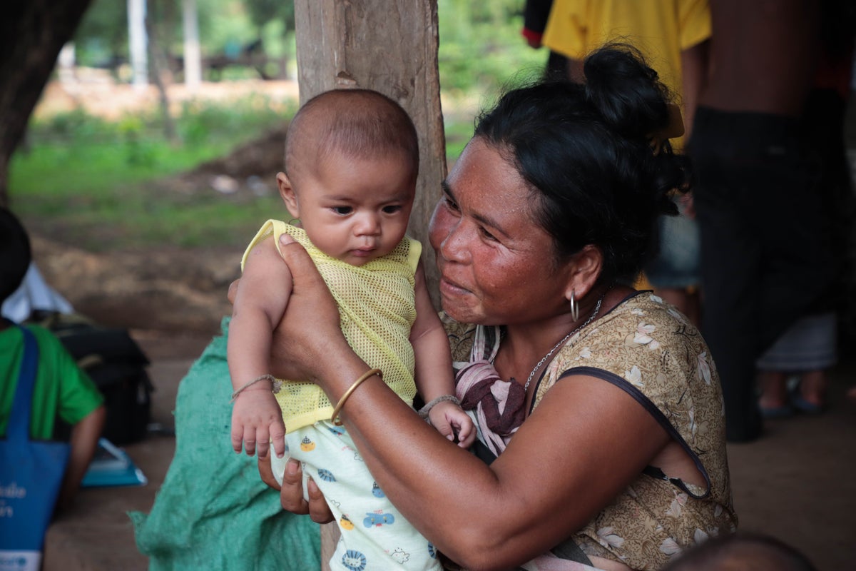 A mother smiles at her baby at a parenting session in Laos.