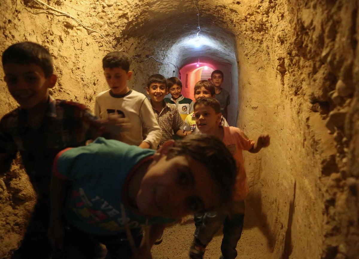Syrian children don't normally feel safe in tunnels - but here, children run gleefully through them.