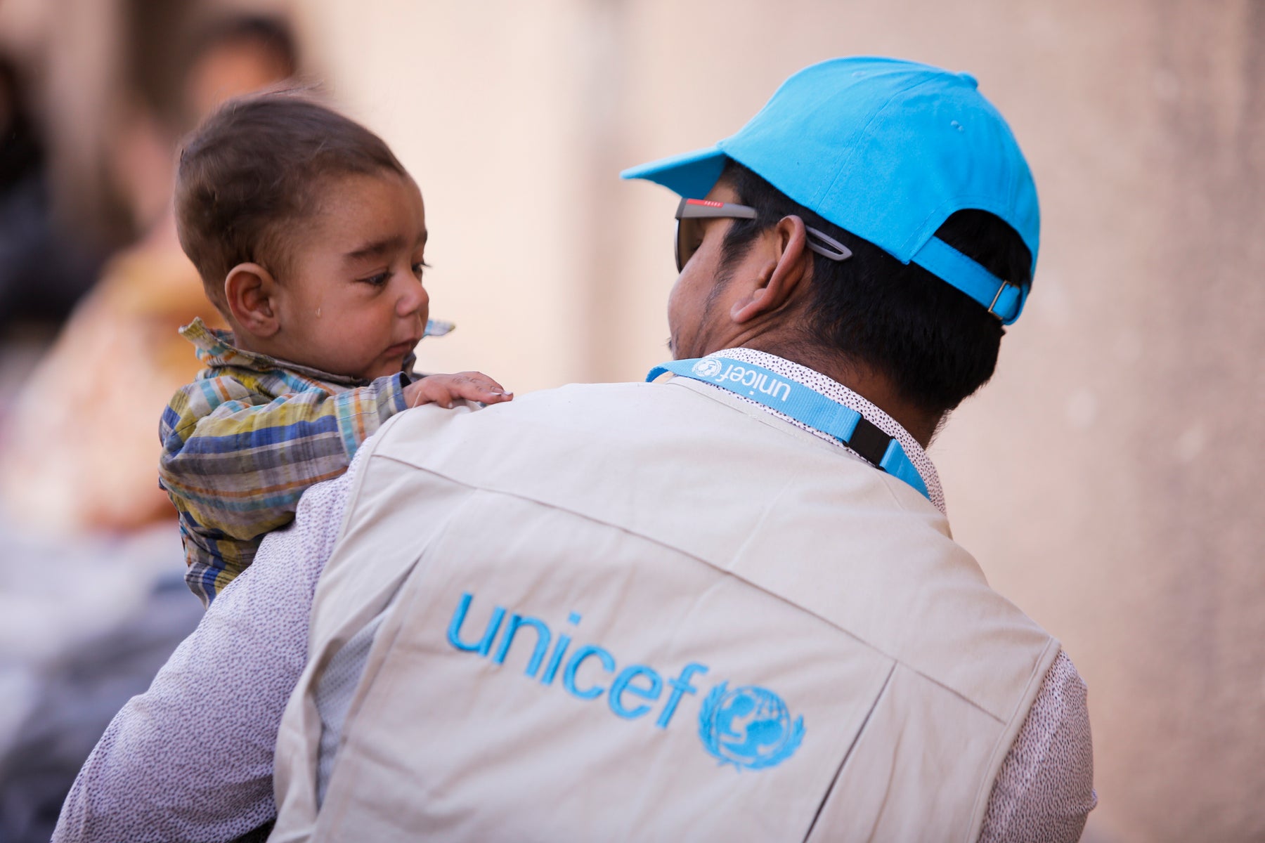 Child crying the arms of a UNICEF worker.