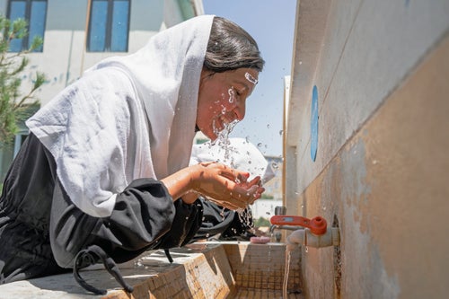 Afghan girl splashing water on their face