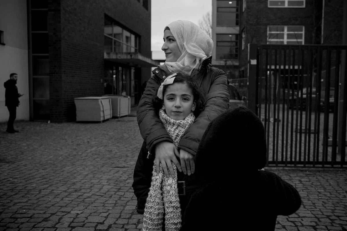 Amira Rasland holds her daughter Jannat outside an emergency shelter on the southern edge of Berlin. 