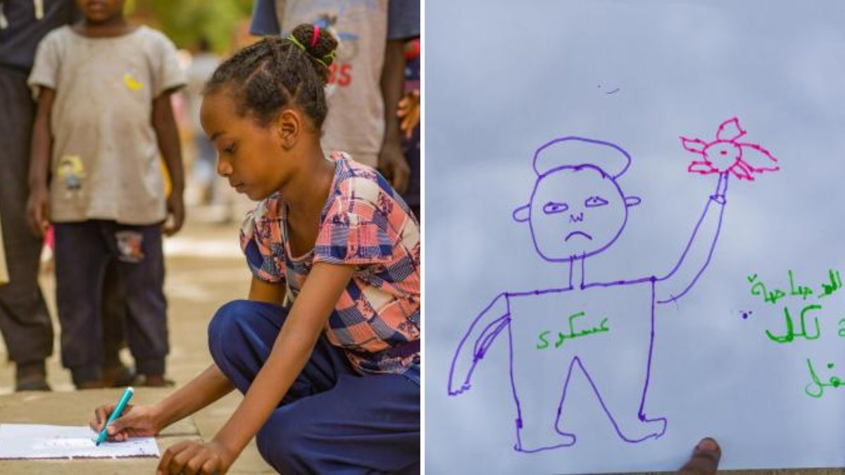 A young girl draws a picture on a piece of paper on the ground. 