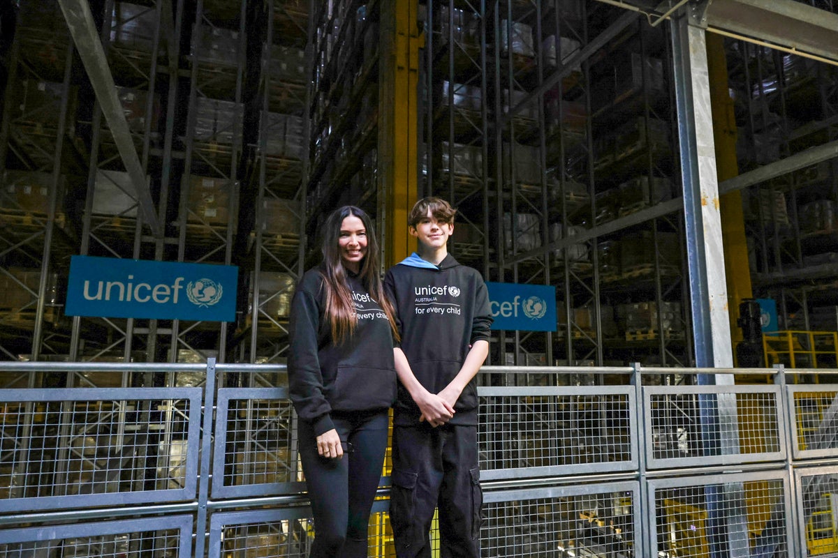 A mother and son standing in a warehouse.