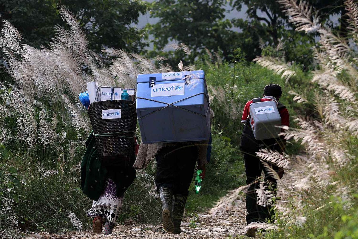 Health care specialists carry vaccines to remote and hard-to-reach children and their families.