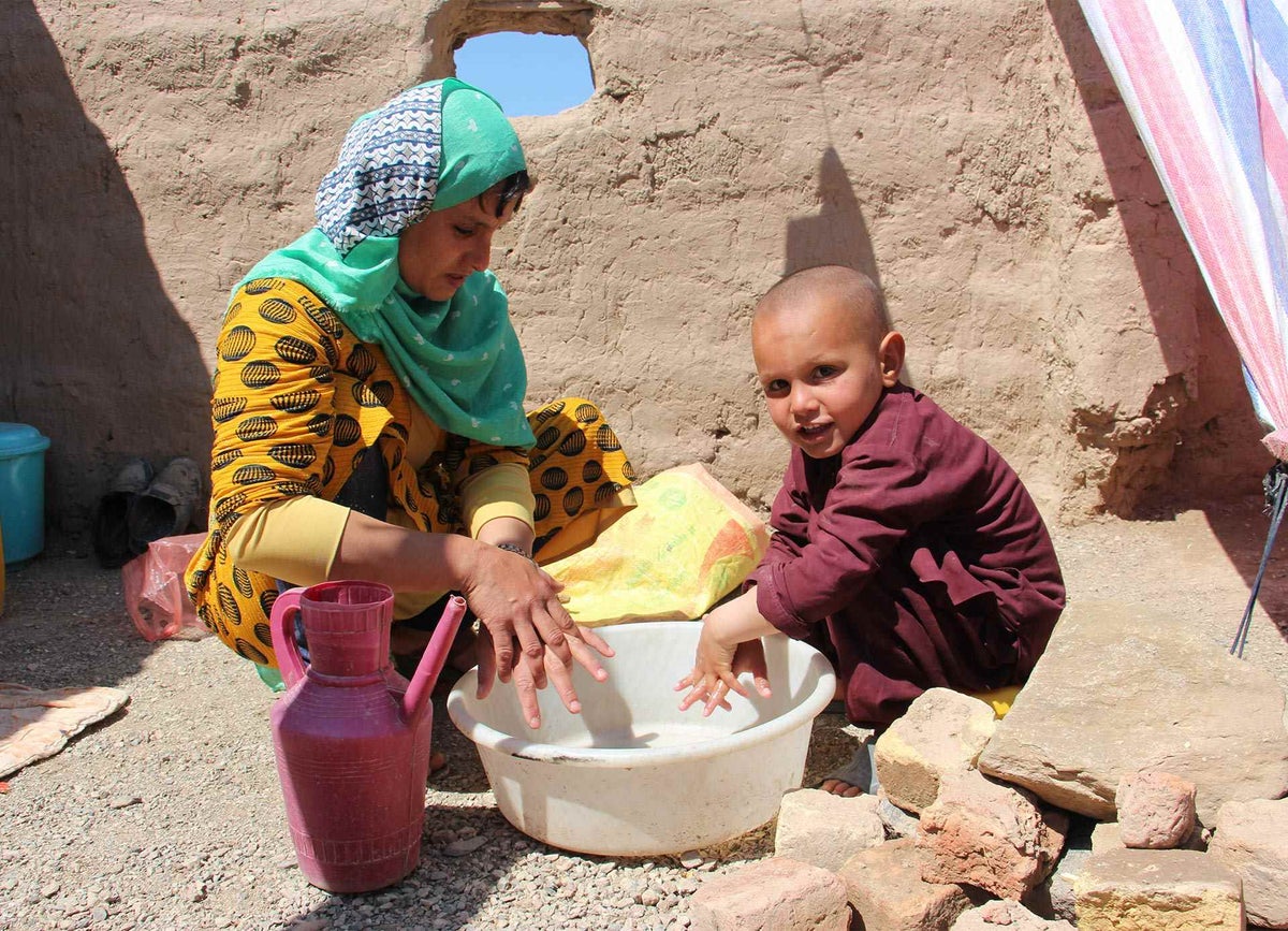 Mother and child wash their hands, Herat, Afghanistan