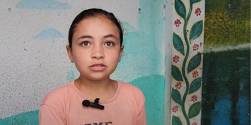 Child in pink shirt in school where they are sheltering during the Gaza crisis