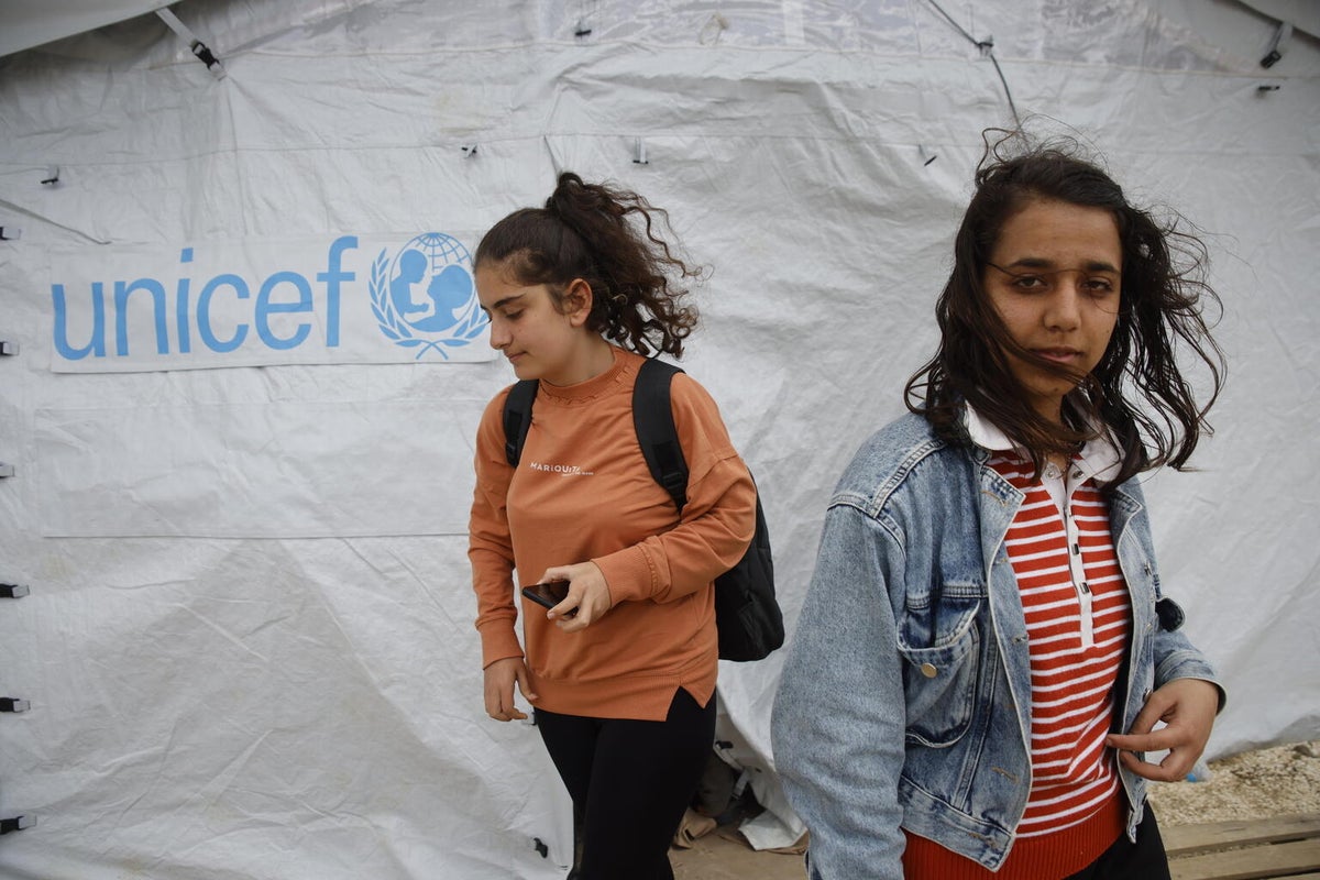 Two girls walk out of a temporary classroom tent in Turkiye