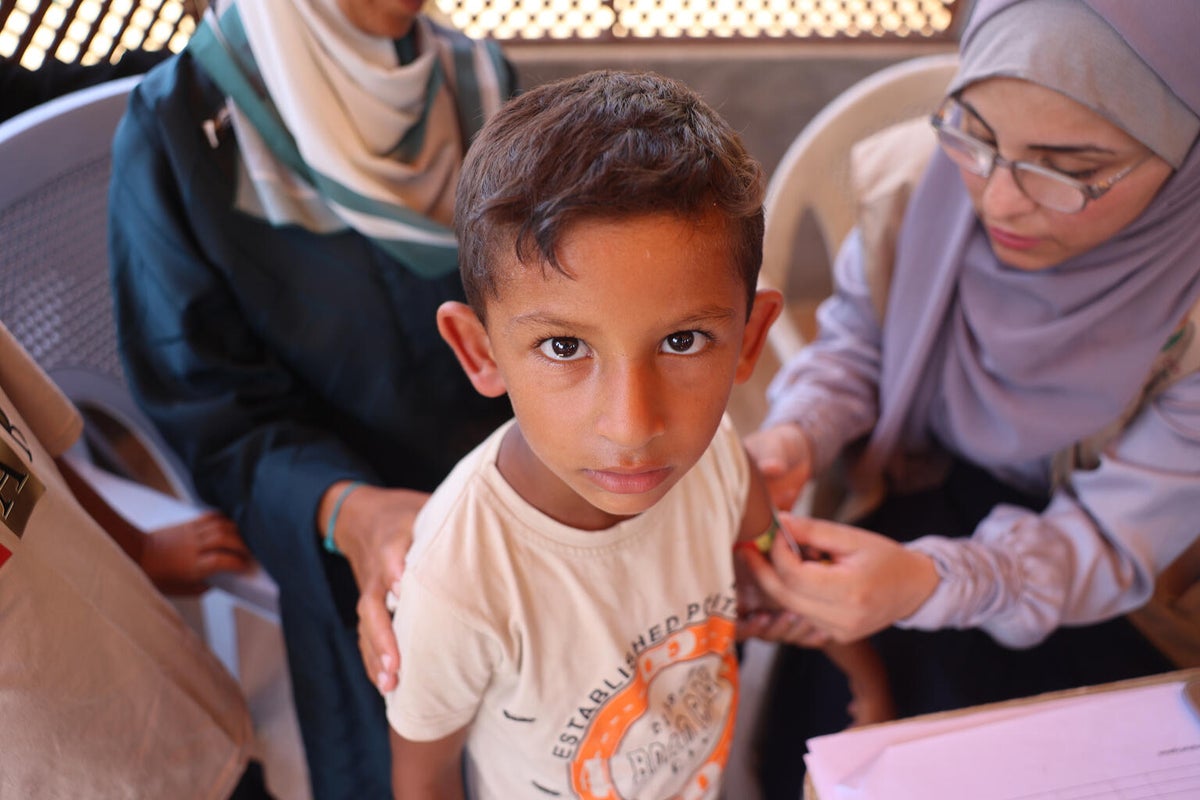 In Gaza, children are getting their middle-upper-arm-circumference (MUAC) measured and are receiving high-energy biscuits as part of their malnutrition screening at a UNICEF-supported health centre.