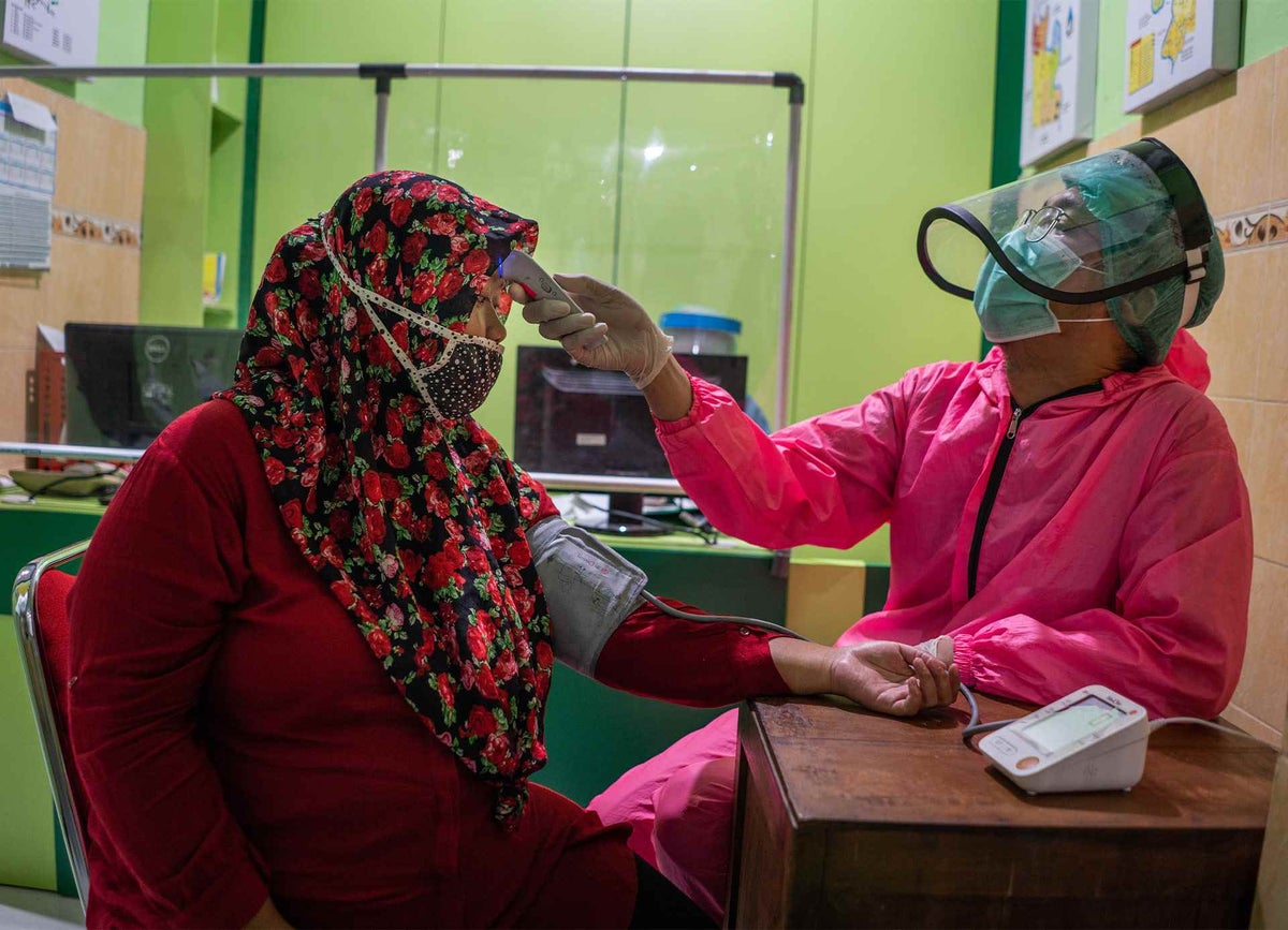 Doctor checking patients temperature and blood pressure