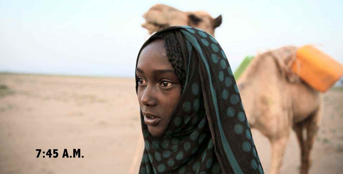 Close up of girl walking with camel