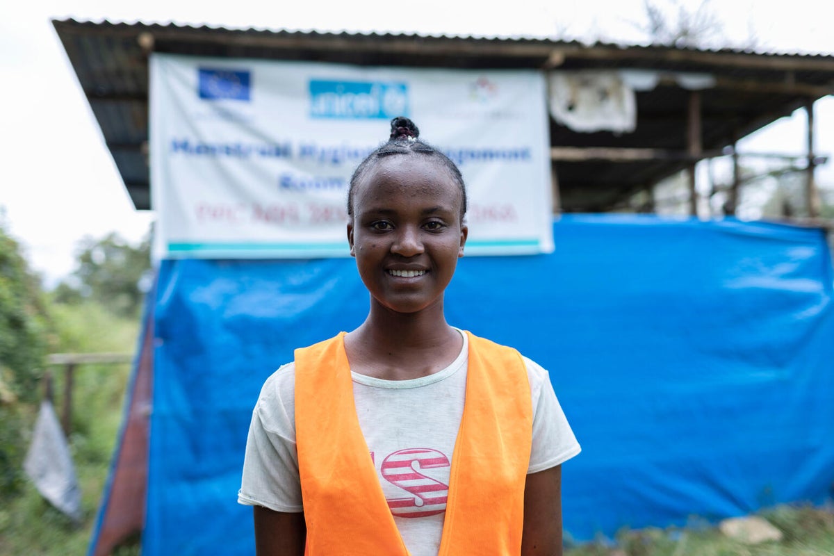 A young girl stands in front of her school building in Ethiopia.