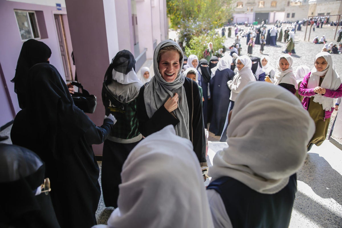 A woman is talking with a group of women on the street.