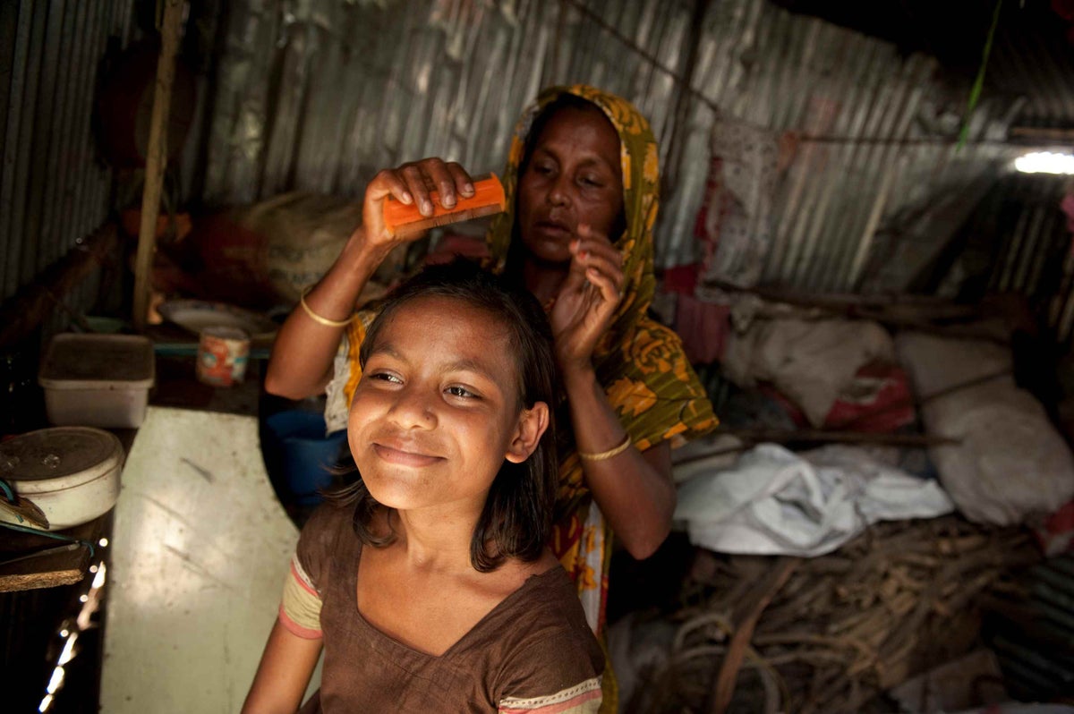 A mother brushes her daughter’s hair in Dhaka, Bangladesh in 2013. 