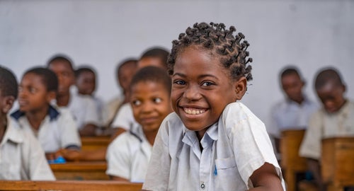 A school kid smiling at the camera