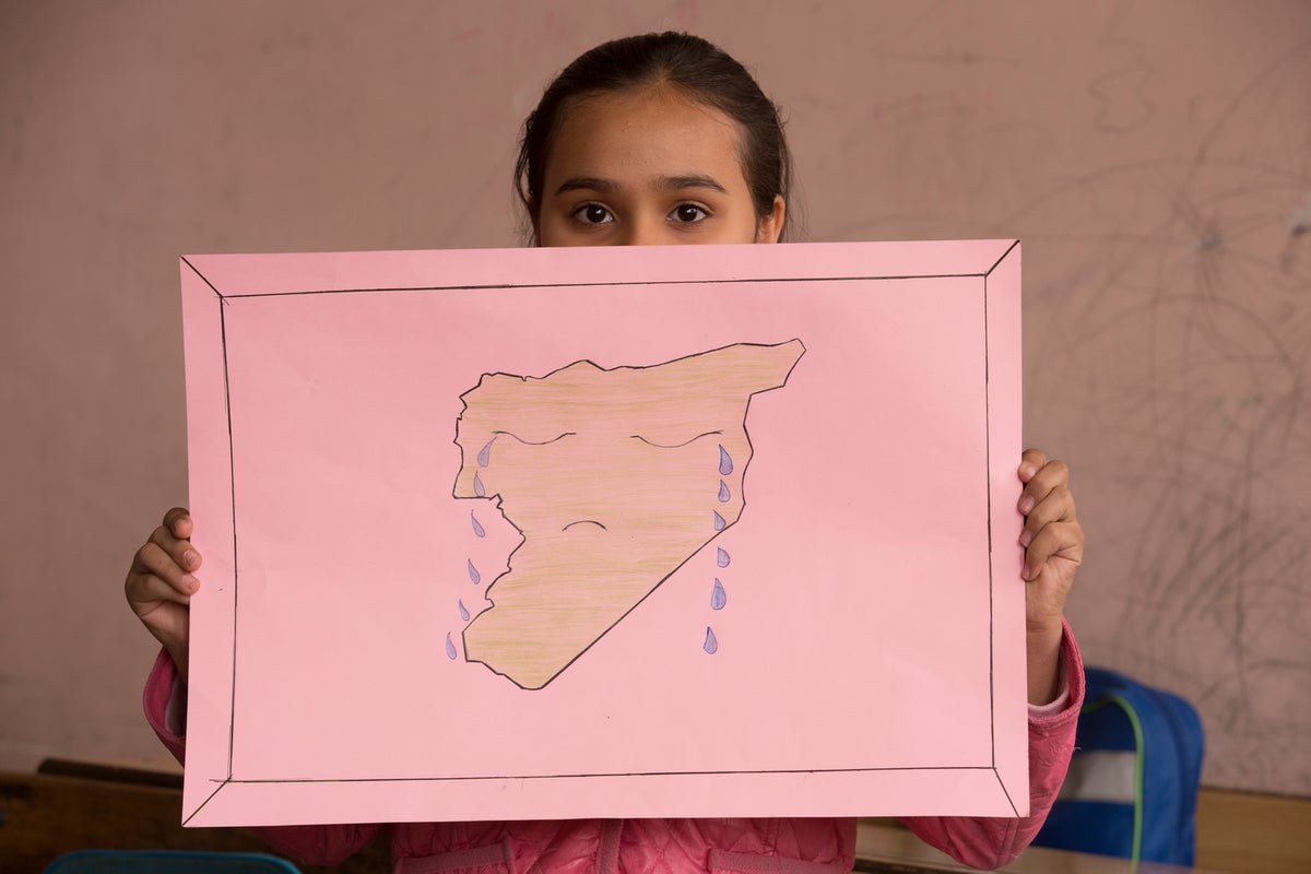 Child showing their drawing of Syria