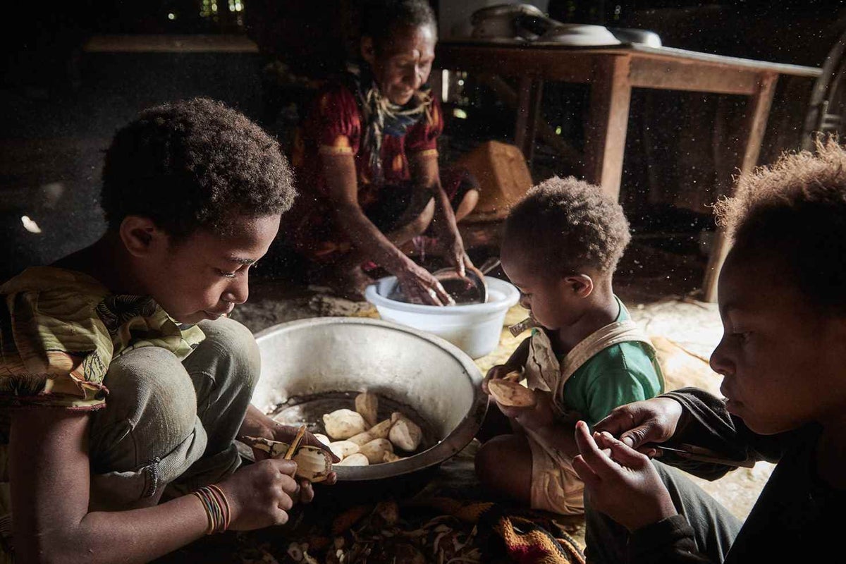 Tobia’s grandchildren help her peel potatoes from the garden. Since participating in the program, Tobia says her grandchildren listen to her more and help with household chores. 