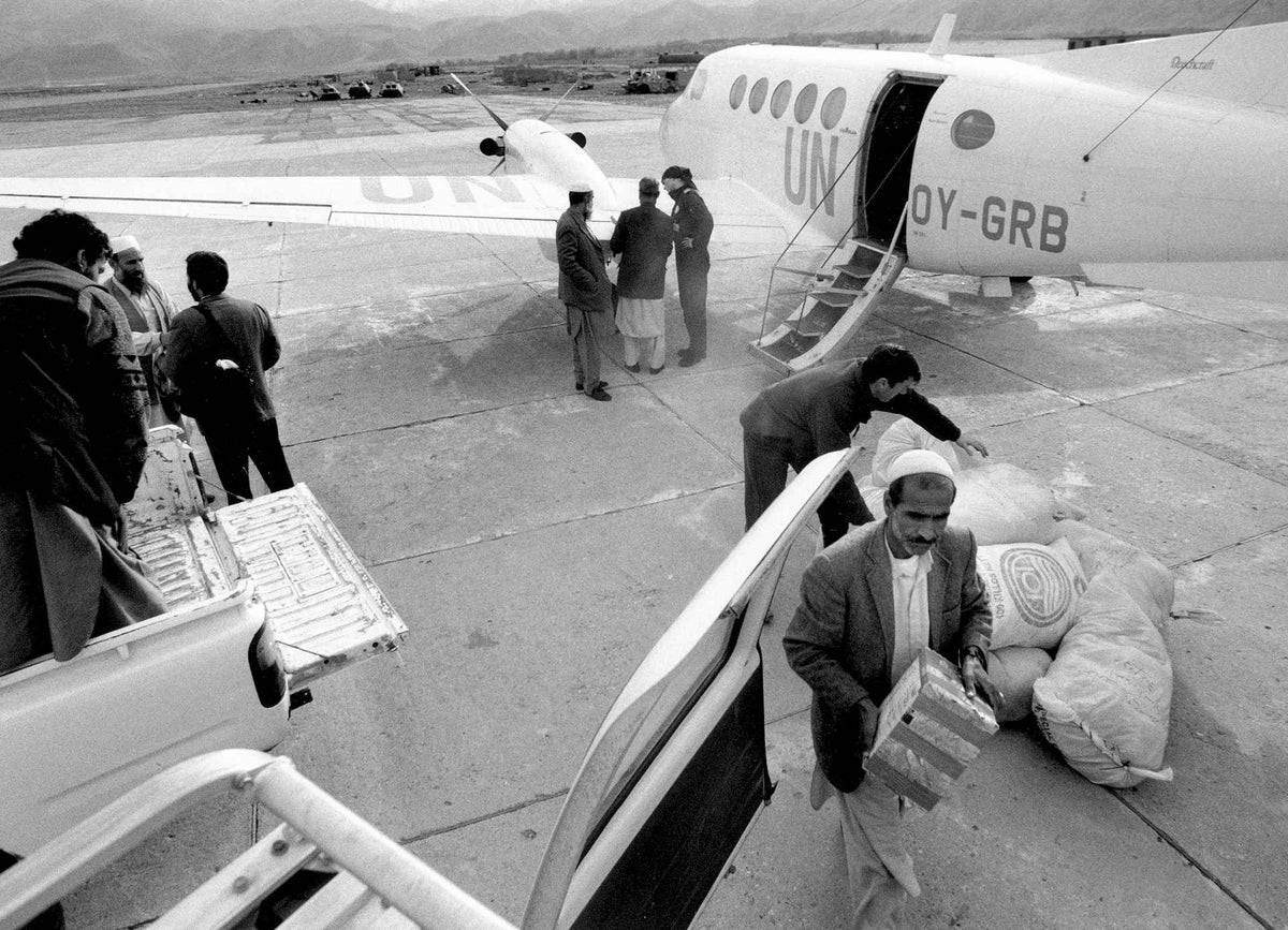Workers load relief supplies, provided by UNICEF, into vehicles at an airport in Faizabad, in 2000.