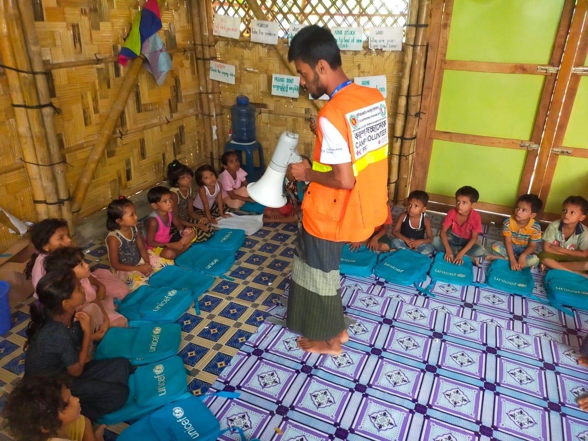 A volunteer speaking to young children in Cox's Bazar. 