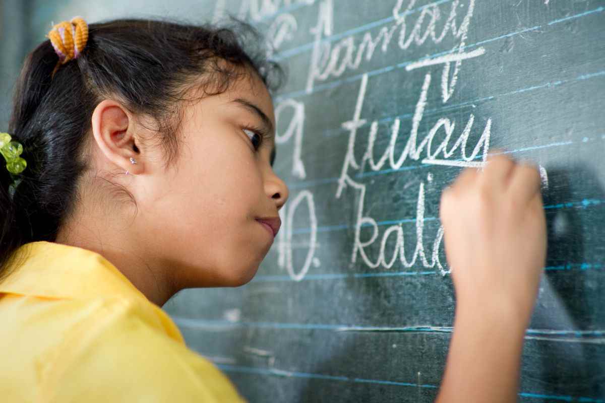 A girl writing on a chalk board