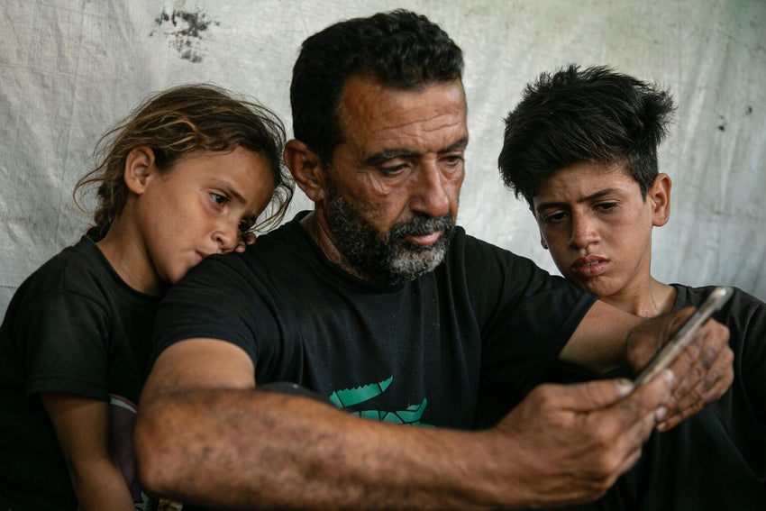 A husband mourns the death of his wife, who was killed while trying to obtain supplies from a non-UN aid distribution site.
