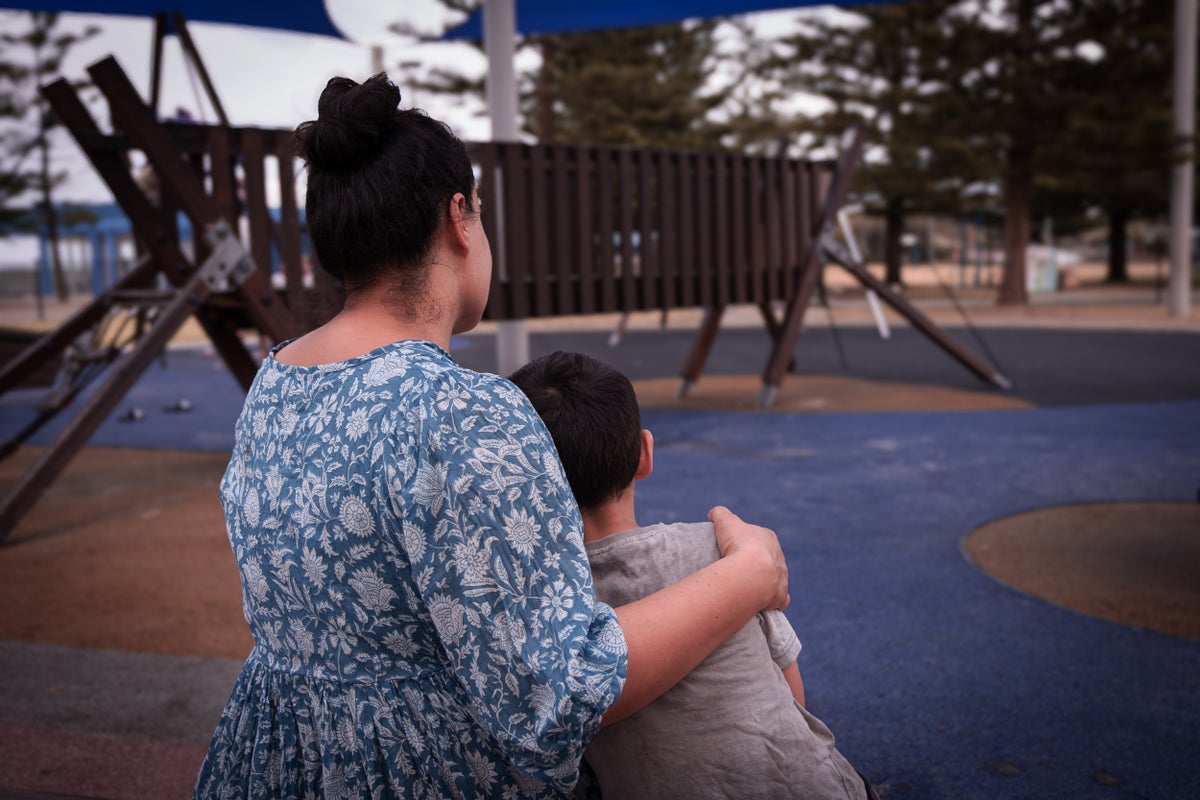 A mother hugs her son.