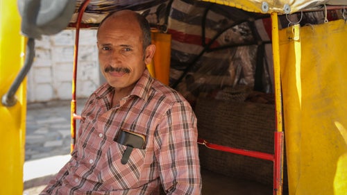 Teacher Mohammed gets prepared to drive drive his tuk-tuk in Sana'a city