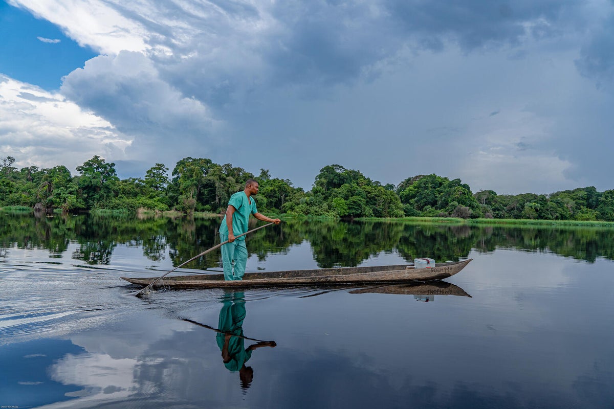 A male nurse boards a dugout canoe and sails on the Ruki River in the Democratic Republic of the Congo to vaccinate the most remote children.