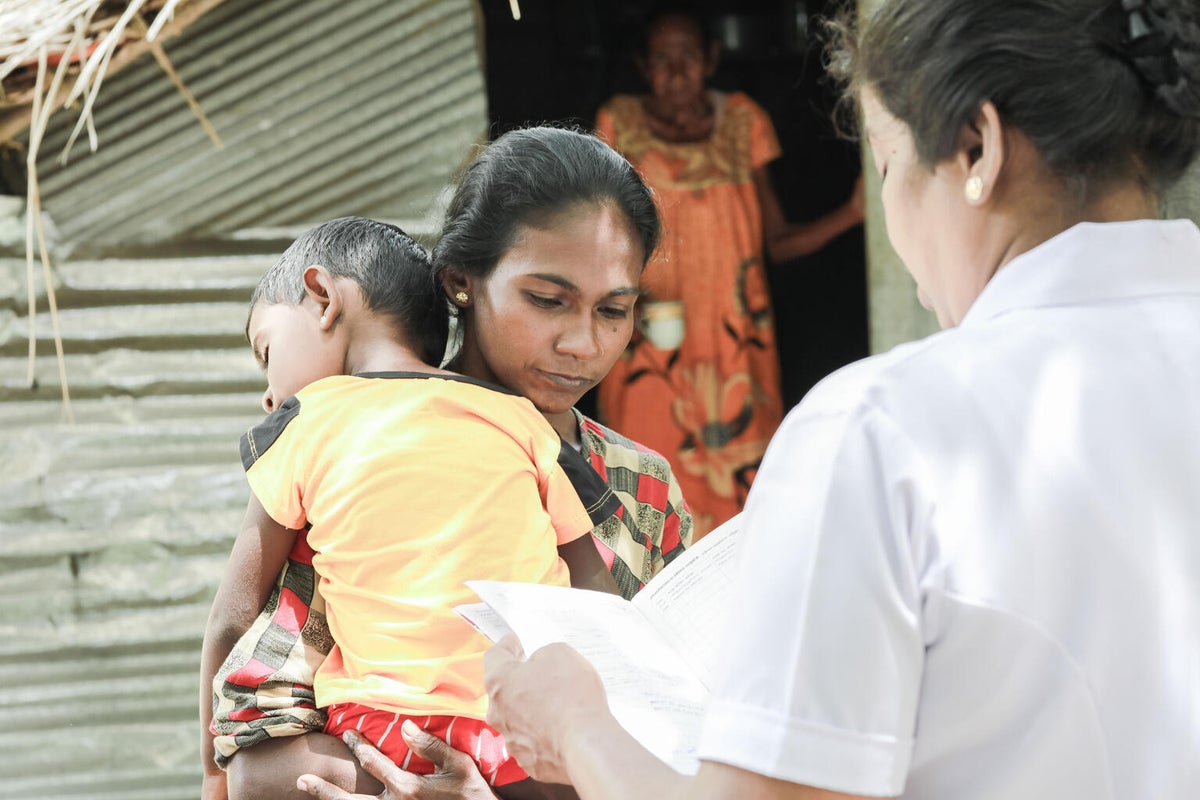 In July 2022, a mother holds her three-year-old son who is suffering from malnutrition. 