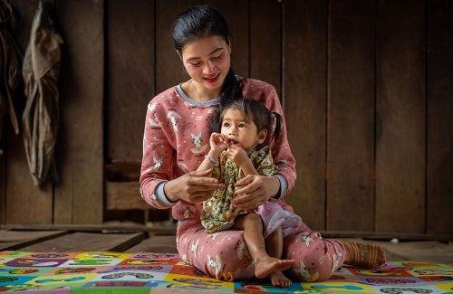 In Cambodia, a mother holds her daughter who has been diagnosed with malnutrition.