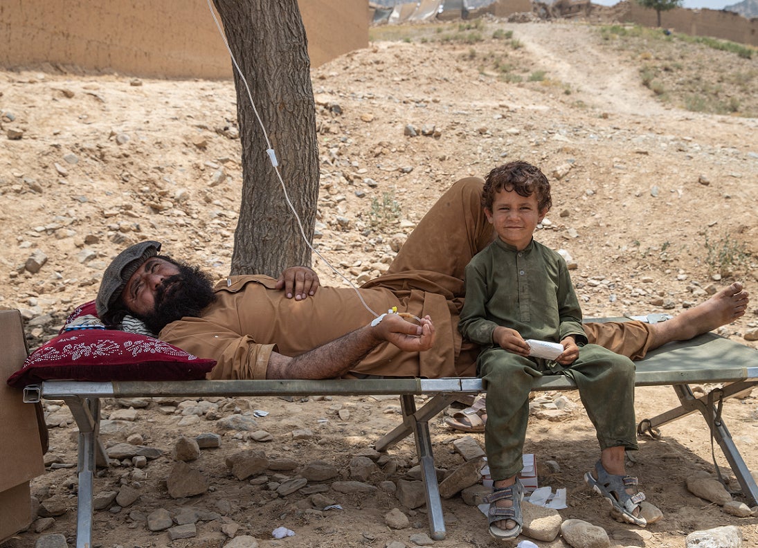 Abdulghafar and his son, Nasim, rest under a tree. 