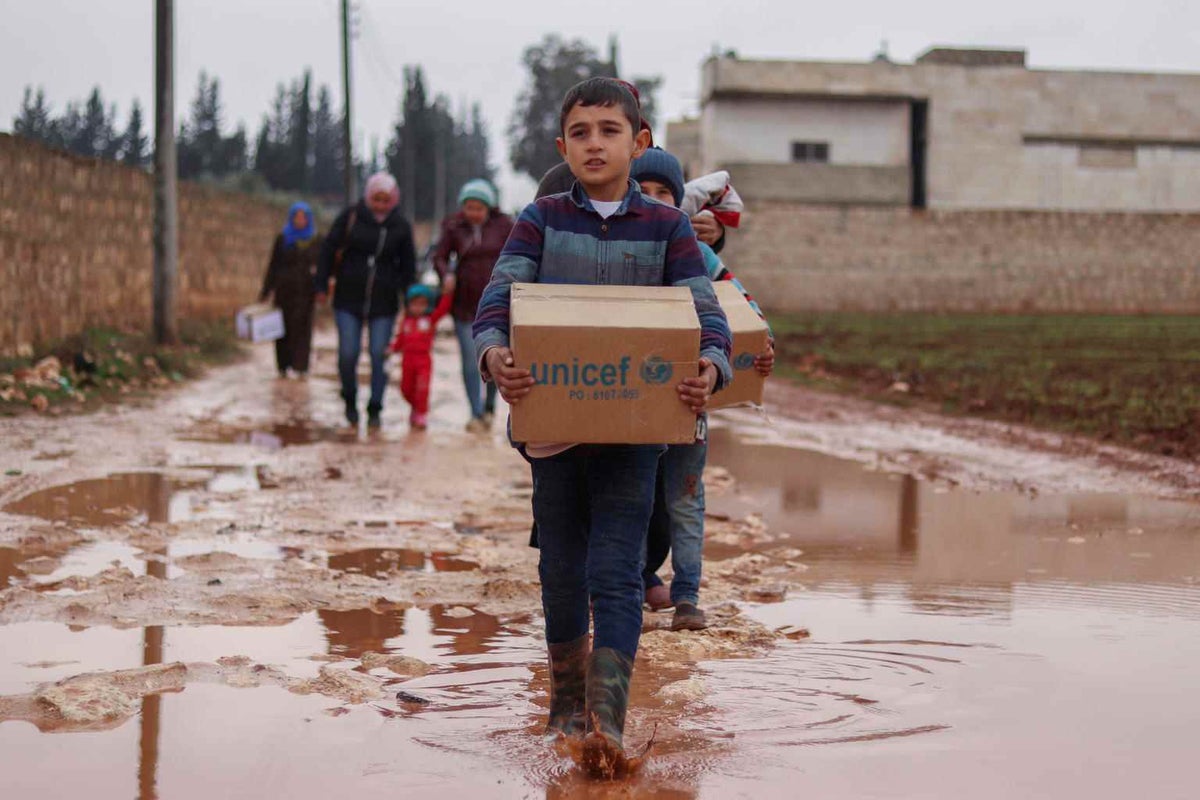 A child carries UNICEF supplies following a delivery in Idlib, Syria.