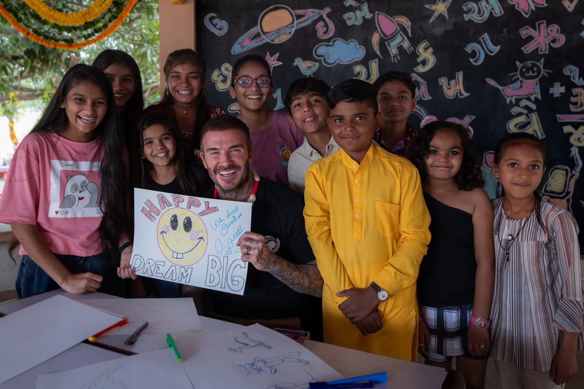 UNICEF Goodwill Ambassador David Beckham holds up a drawing he has made while speaking with a group of adolescents at the community centre in India.