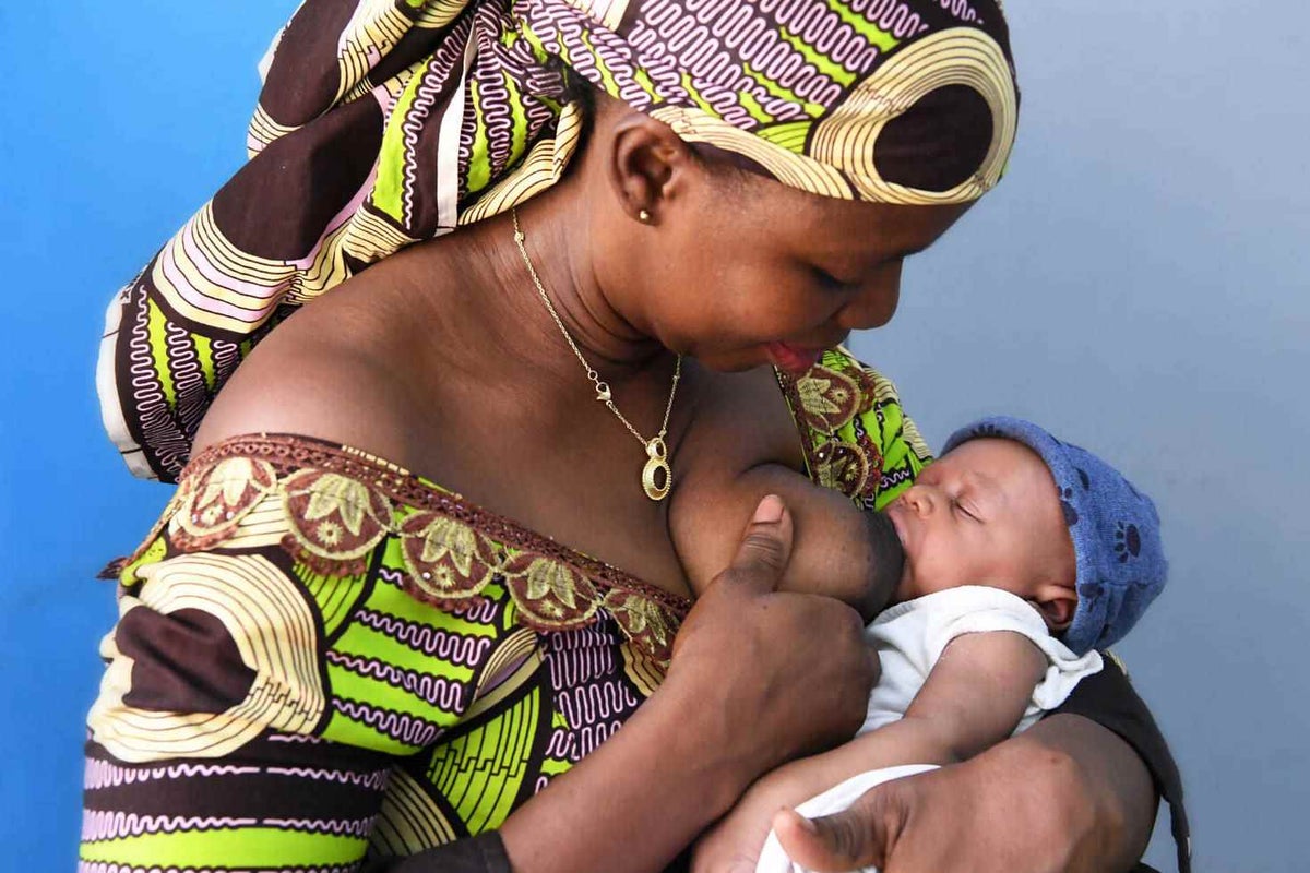 Ely is breastfeeding and cuddling her youngest child, three-week-old Titian.