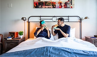 Couple enjoying breakfast in bed at The Collective Paper Factory 