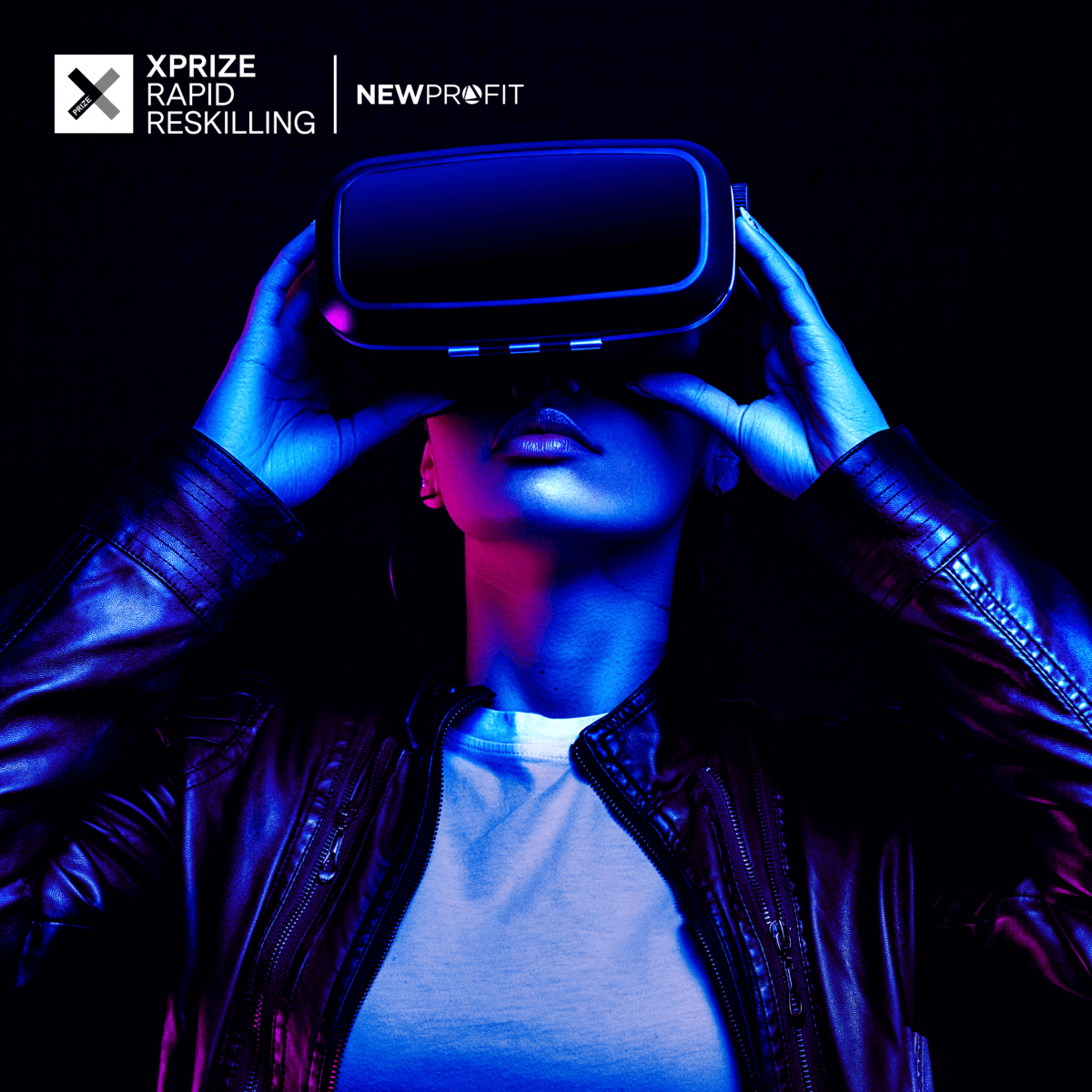 An adult woman holds a VR headset, she is lit with blue light