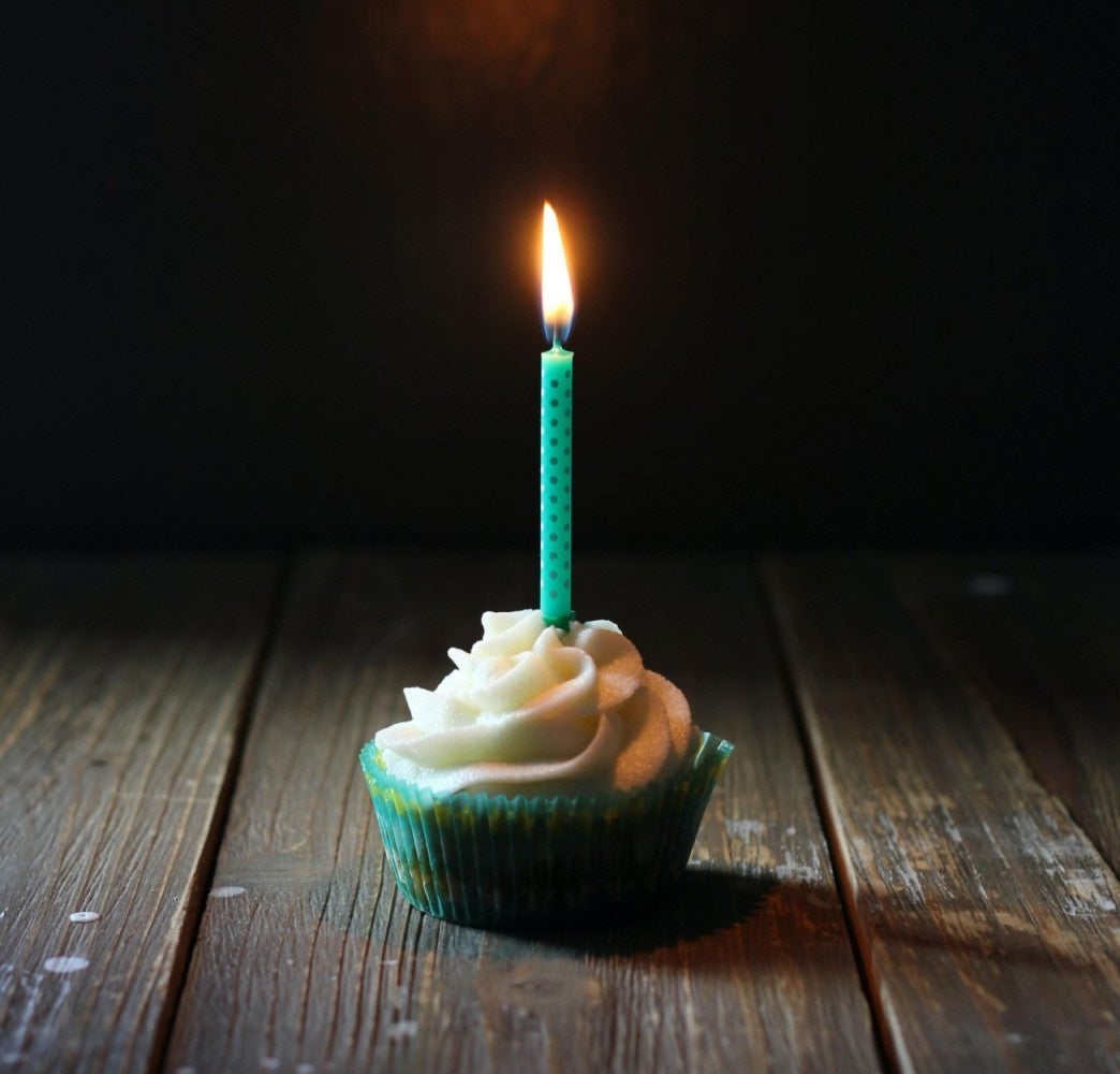 A cupcake with a lit birthday candle in it