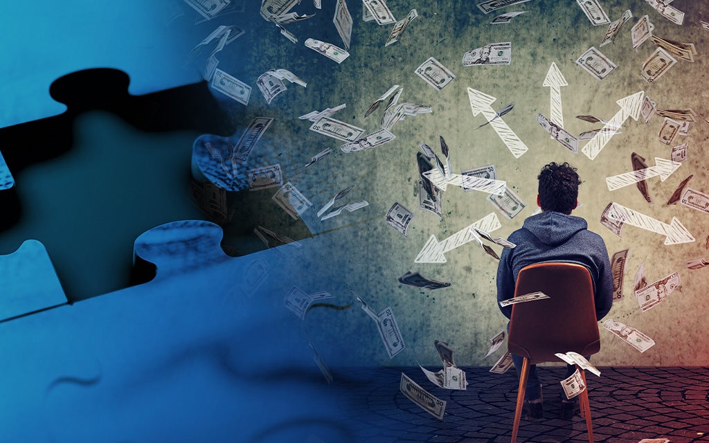Male sitting in a chair with money floating around his head.