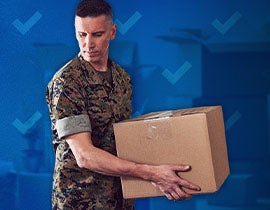 man in military uniform carrying a moving box