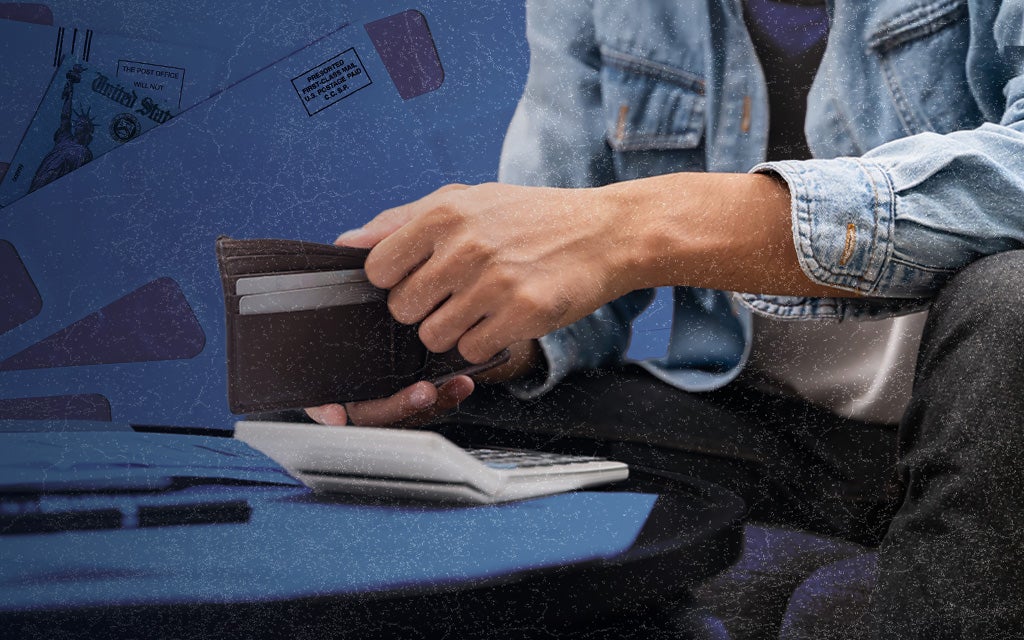 Image of a person opening a wallet while using a calculator.